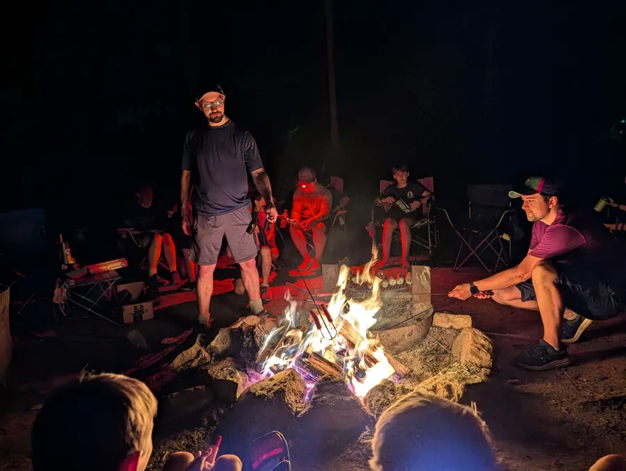 Trailmen and leaders around a campfire after dark