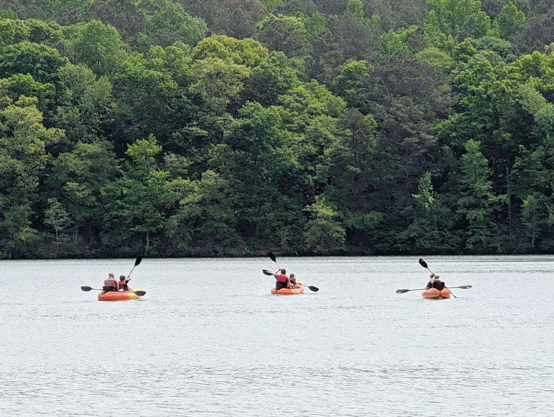 Trailmen paddling kayaks on a lake at Hard Labor Creek